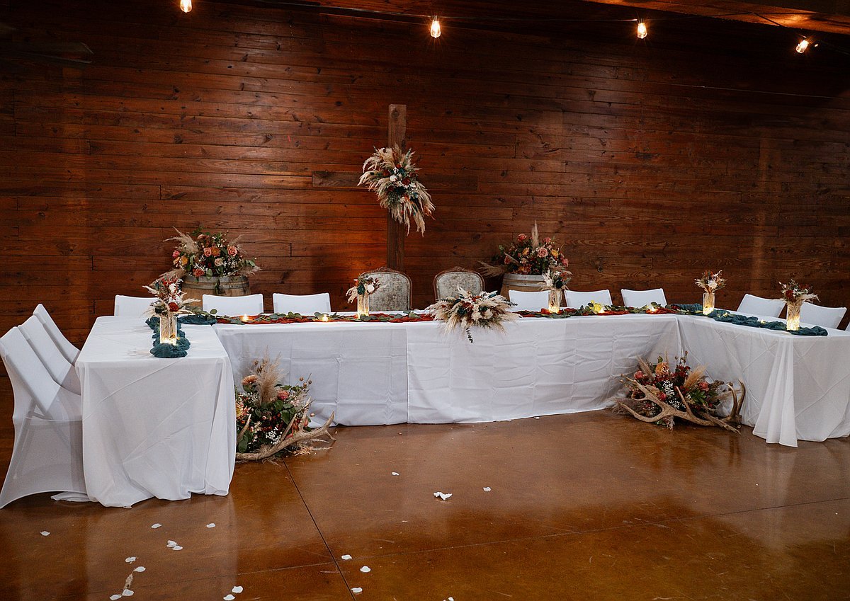 Beautifully decorated head table with teal runner candles and pampas grass